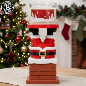 May include: A candle holder featuring a Santa Claus figure stuck upside down in a brown brick chimney. The figure wears red pants with a black belt and white trim. A clear glass candle with a red label depicting white trees and snowflakes sits on top.