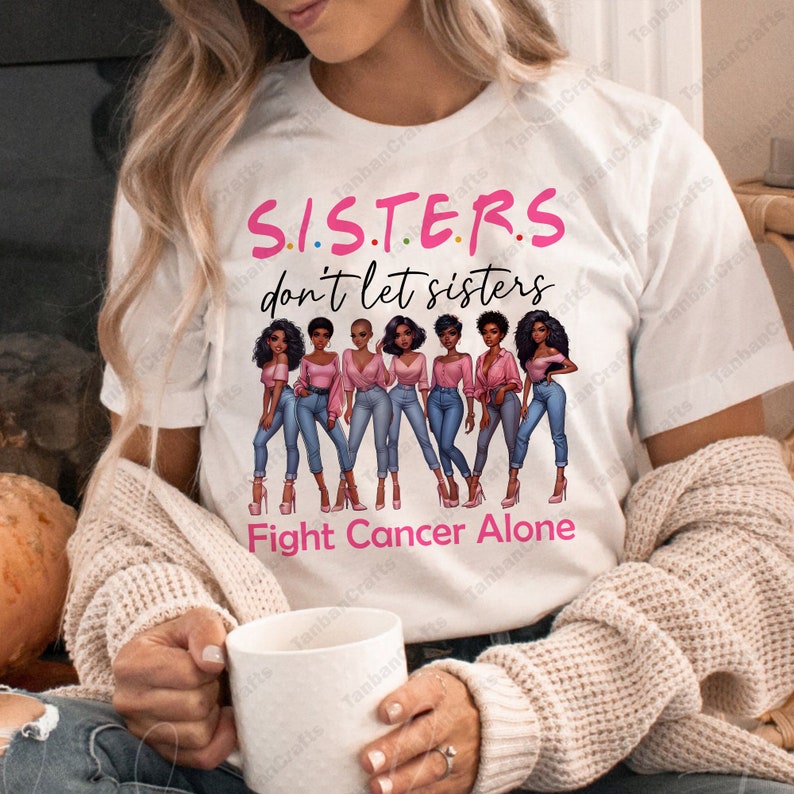 May include: White t-shirt with the text "S.I.S.T.E.R.S don't let sisters Fight Cancer Alone". The shirt features a graphic of seven women in pink tops and blue jeans.