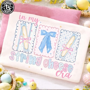 Könnte beinhalten: Eine weiße Keramiktasse mit schwarzem Henkel und dem Text "But First, Coffee" in fetter, schwarzer Schrift. Die Tasse steht vor einem verschwommenen Hintergrund, der eine gemütliche Umgebung suggeriert.