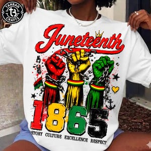 May include: White t-shirt with a colourful graphic celebrating Juneteenth. The design features three fists in red, yellow, and green, chained together, with the word "Juneteenth" in red script above the year "1865". The shirt also includes the words "Story Culture Excellence Respect".