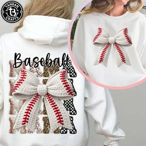 Könnte beinhalten: Weißes Sweatshirt mit einem Baseball-Schleifendesign mit roten Nähten. Das Wort "Baseball" ist in schwarzer Schrift über der Schleife aufgedruckt. Das Design umfasst Basebälle mit Leoparden- und Schachbrettmustern. Ein kreisförmiges Logo befindet sich in der oberen linken Ecke.