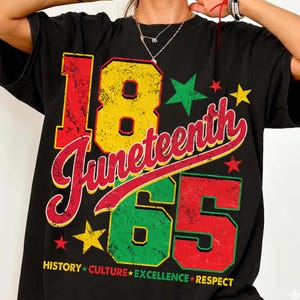 Puede incluir: Camiseta negra con un gráfico colorido que celebra el Juneteenth. El diseño presenta los números "18" y "65" en rojo, amarillo y verde, con "Juneteenth" en una fuente cursiva. Las palabras "HISTORY CULTURE EXCELLENCE RESPECT" están en la parte inferior.