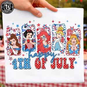 Könnte beinhalten: Weißes dekoratives Handtuch mit fünf Cartoon-Prinzessinnen in rot-weiß-blauen patriotischen Designs. Das Handtuch trägt die Aufschrift "happy 4th of July" in blauer und roter Schrift, mit Sternen und Feuerwerksakzenten. Das Handtuch wird von einer Hand gehalten.