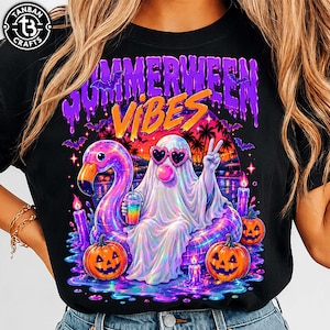 May include: A black t-shirt featuring a graphic of a ghost wearing heart-shaped sunglasses and blowing a bubble, sitting on a pink flamingo pool float. The design includes two jack-o'-lanterns, purple candles, bats, and the text "SUMMERWEEN VIBES".