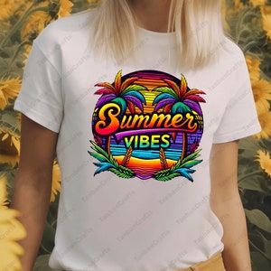 K&ouml;nnte beinhalten: Ein wei&szlig;es T-Shirt mit einem bunten Grafikdesign von Palmen, einem Sonnenuntergang und dem Text "Summer Vibes".