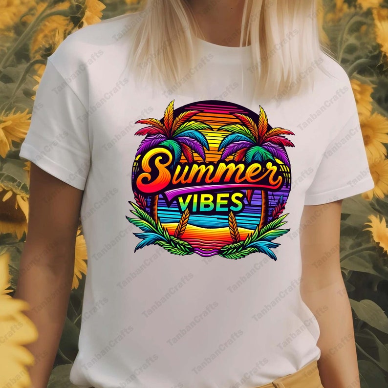 K&ouml;nnte beinhalten: Ein wei&szlig;es T-Shirt mit einem bunten Grafikdesign von Palmen, einem Sonnenuntergang und dem Text "Summer Vibes".