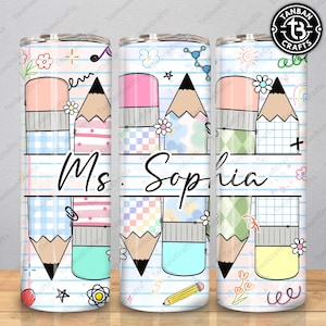 May include: A personalized tumbler featuring a pencil design with the name "Ms. Sophia" in a cursive font. The design includes pencils, erasers, and decorative elements on a lined paper background. The tumbler is cylindrical and has a clear lid.