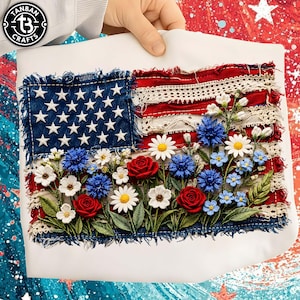 May include: Embroidered American flag design with white stars on a blue denim patch, red and white stripes, and a floral arrangement of red roses, white daisies, and blue flowers. The flag is on a white background.