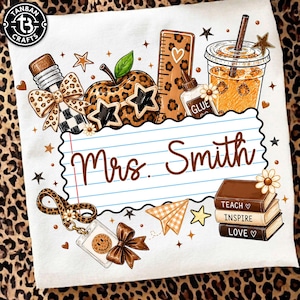May include: A white t-shirt featuring a graphic design with a lined paper center containing the text Mrs. Smith. Surrounding elements include a leopard print apple with star-shaped glasses, a pencil, a ruler, glue, a drink, and a stack of books.