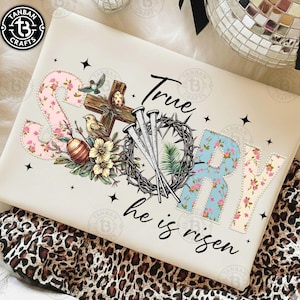 Puede incluir: Cojín crema con la frase "True Story, he is risen". El diseño incluye letras florales, una cruz de madera, clavos, una corona de espinas y huevos de Pascua.