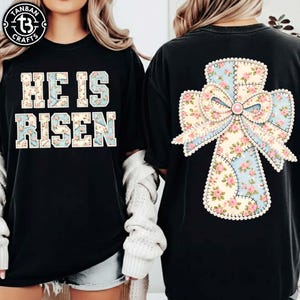 Könnte beinhalten: Schwarze T-Shirts mit dem Text "HE IS RISEN" in einem floralen Design auf der Vorderseite. Die Rückseite des Shirts zeigt ein Kreuzdesign mit einer Schleife, ebenfalls in einem floralen Muster. Die Shirts sind Teil eines religiösen Themas.