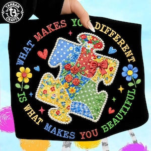 Puede incluir: Bolso tote negro con un diseño de pieza de rompecabezas colorido y el texto "WHAT MAKES YOU DIFFERENT IS WHAT MAKES YOU BEAUTIFUL." La pieza del rompecabezas está decorada con patrones florales y de lunares, y un lazo rojo.