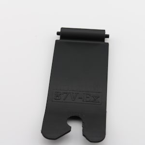 May include: Black plastic strap with a metal loop and the text "87V-EX" printed on it.