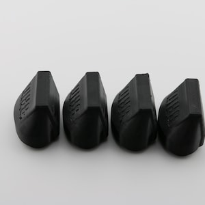 May include: Four black rubber valve stem caps with the word "Valve" embossed on each cap.