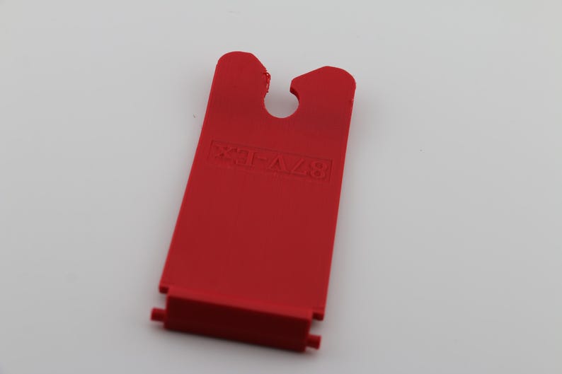 May include: Red plastic piece with a hole in the center and the text "EXTRA" printed on it.