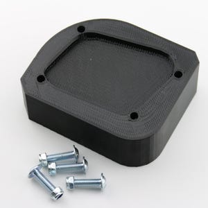 May include: A black plastic 3D printed part with a rectangular opening and five screw holes. Five silver screws are included.