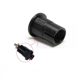 Puede incluir: Un conector de plástico negro con un pequeño motor cilíndrico negro unido a él. El motor tiene un pequeño eje de color dorado.