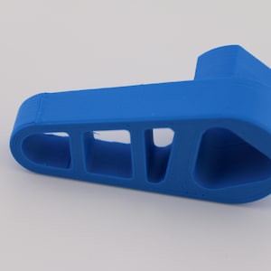 Könnte beinhalten: Ein hellblaues, 3D-gedrucktes Objekt aus Kunststoff mit einer Reihe rechteckiger Ausschnitte. Das Objekt hat eine abgerundete, leicht gekrümmte Form.