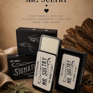 Op de afbeelding: Een zwart rechthoekig blikje met vaste parfum, gelabeld MR. SULTRY BY MANLY CLUB, met een schuifdeksel dat een crèmekleurige balsem onthult. De verpakking bevat zwarte doosjes met witte tekst, met de geurnoten zeebries, sandelhout, scharlei, amber en donker leer. Het product wordt getoond naast vanillestokjes, amberhars en salieblaadjes.
