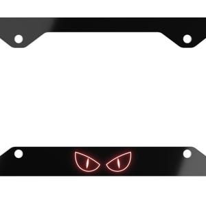 Puede incluir: Marco de matrícula negro con un diseño de ojos rojos brillantes. El marco es rectangular con esquinas redondeadas y orificios de montaje. El diseño de los ojos está en la parte inferior central.