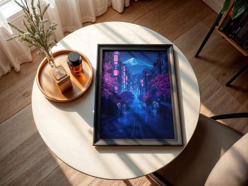 May include: A framed print of a digital painting depicting a nighttime cityscape with a mountain in the background. The city is illuminated with neon lights and pink cherry blossoms. The print is in a black frame.