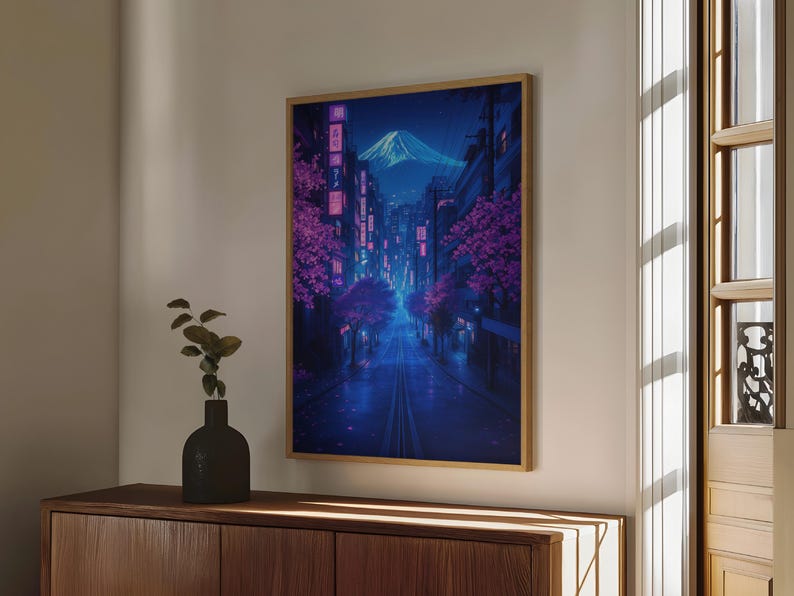 May include: A digital art print of a city street at night with a mountain in the background. The street is lined with trees with pink blossoms and buildings with neon lights. The sky is dark blue with a few stars.
