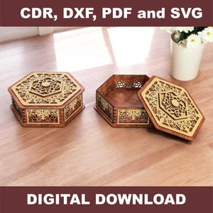 May include: Two wooden hexagonal boxes with detailed laser-cut patterns. One box is closed, the other is open with the lid beside it. The boxes are brown with gold accents. Text at the top reads "CDR, DXF, PDF and SVG" and at the bottom "DIGITAL DOWNLOAD".