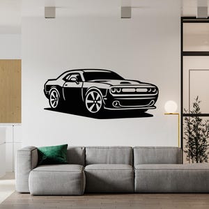 以下が含まれることがあります： 白い壁に描かれた、白黒のスポーツカーのグラフィック。 車は大きなホイールと詳細なフロントグリルを備えたクーペです。 この画像は、家の装飾に適したウォールデカールです。