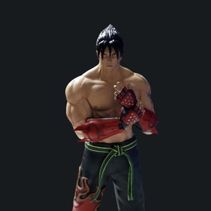 Può includere: Una action figure rossa e nera di un personaggio maschile con i capelli neri a punta, che indossa guanti rossi e neri e una cintura nera con una striscia verde. La figura è in posizione di combattimento.