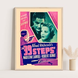 May include: A vintage film poster for the movie "The 39 Steps" directed by Alfred Hitchcock. The poster features a man and woman in a dramatic scene with a gun. The text on the poster reads "A hair-raiser of suspense!" and "Alfred Hitchcock's The 39 Steps" with the actors' names, Madeleine Carroll and Robert Donat.