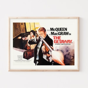 以下が含まれることがあります： スティーブ・マックイーンとアリ・マッグロー主演の映画「逃亡者」の映画ポスター。ポスターは、マックイーンがショットガンを持ち、マッグローがピストルを持っている劇的なシーンを描いています。ポスターは木製の額縁に入っています。