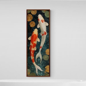 Op de afbeelding: Een ingelijst schilderij van twee koi-karpers die zwemmen in een vijver met waterlelies. De vissen zijn oranje, wit en zwart. De achtergrond is donkerblauw met groene waterlelies.
