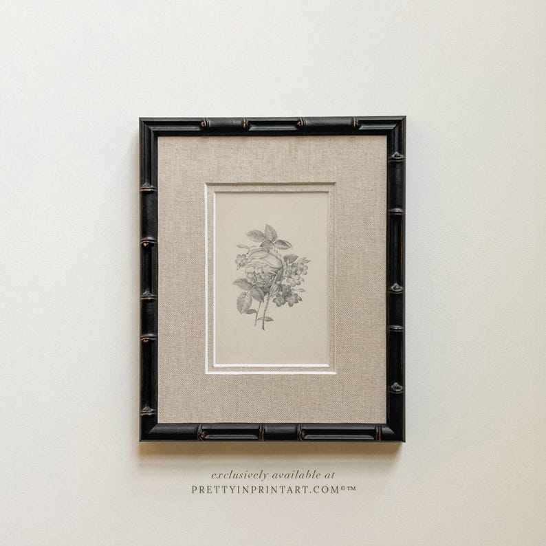 May include: A framed botanical print featuring a detailed black and white illustration of flowers and leaves. The print is set within a neutral linen mat and a black bamboo-style frame. The text "exclusively available at PRETTYINPRINTART.COM" is at the bottom.