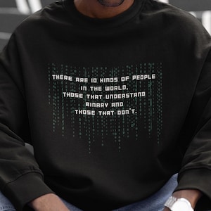Puede incluir: Una sudadera negra con un gráfico de texto verde que dice "THERE ARE 10 KINDS OF PEOPLE IN THE WORLD. THOSE THAT UNDERSTAND BINARY AND THOSE THAT DON'T."