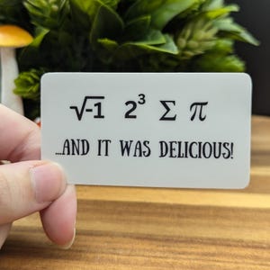 May include: White sticker with black text that reads "√-1 2³ Σ π ...AND IT WAS DELICIOUS!"