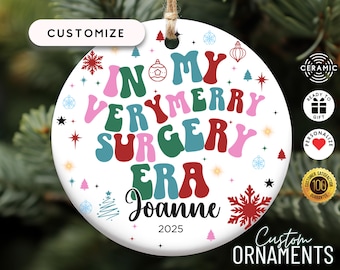 May include: White ceramic Christmas bauble with a colourful retro design that says "In My Very Merry Surgery Era" with a name and the year 2025.
