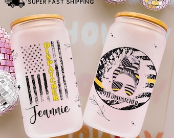 Könnte beinhalten: Zwei Glasbecher mit Bambusdeckeln. Einer hat ein amerikanisches Flaggen-Design mit dem Wort "DISPATCHER" und dem Namen "Jeannie". Der andere hat ein 911 Dispatcher-Design mit einem Dutt.