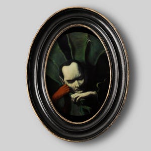 Op de afbeelding: Ovaal ingelijst kunstwerk met een sombere figuur met een bleke huid, die zijn hoofd op een rood gehandschoende hand laat rusten. De achtergrond is donker met groen gebladerte. De lijst is zwart met een gouden rand.