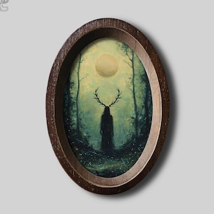 Op de afbeelding: Een ovaalvormige donkerbruine houten lijst met een schilderij van een donker silhouet met een groot hertengewei, staand in een mistig bos onder een bleke, gloeiende volle maan. De scène bevat overal diepe groen- en blauwtinten.