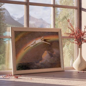 May include: A framed artwork depicts a nude figure floating on a rainbow. The artwork is in a light wood frame and rests on a wooden surface near a window. A vase with red berries and a small black vase with red berries are also on the surface.