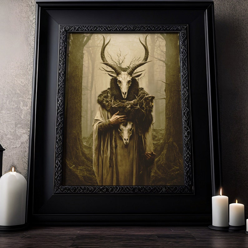 May include: A framed art print featuring a figure with a deer skull head, wearing a fur-lined cloak and holding a skull. The artwork is set against a misty forest backdrop, with a dark, ornate frame. The overall color palette is muted with earthy tones.