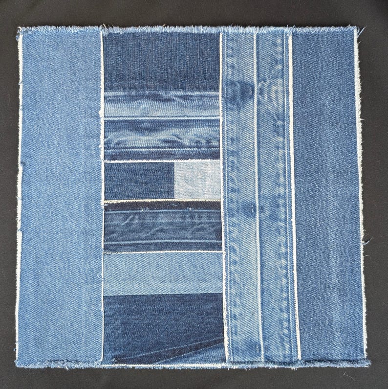 Pu&ograve; includere: Patchwork quadrato in denim con varie tonalit&agrave; di blu. Il design presenta strisce rettangolari e verticali di denim, creando un motivo geometrico strutturato. I bordi sono grezzi e non rifiniti, con cuciture bianche.