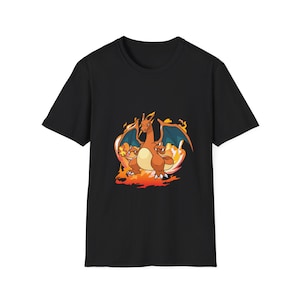 Puede incluir: Camiseta negra con un diseño de Charizard de dibujos animados. El gráfico muestra un Charizard naranja con alas azules y llamas. El diseño está centrado en la parte delantera de la camiseta.