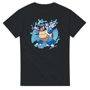 Puede incluir: Camiseta negra con una ilustración de dibujos animados de una criatura azul con forma de tortuga con efectos de agua. La criatura tiene una barriga beige, un caparazón azul y dos cañones en la espalda.