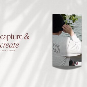 May include: A white long-sleeve shirt with the word "MO" printed on the back. The person is wearing a black knit hat and is standing by a body of water.
