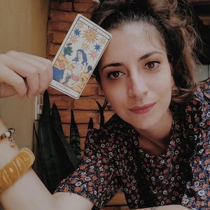 Tarot reader holding The Star card, hope and healing tarot symbolism, intuitive psychic portrait