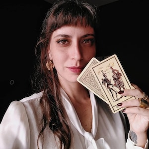 Tarot reader holding vintage tarot cards, intuitive psychic portrait, authentic tarot reading energy