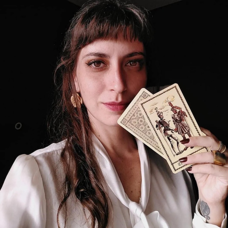 Tarot reader holding vintage tarot cards, intuitive psychic portrait, authentic tarot reading energy