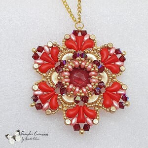 Puede incluir: Un collar con un colgante de flor de cuentas rojas y doradas. El colgante es una estrella de seis puntas con un centro rojo y cuentas doradas alrededor de los bordes. El collar est&aacute; hecho de cadena dorada.