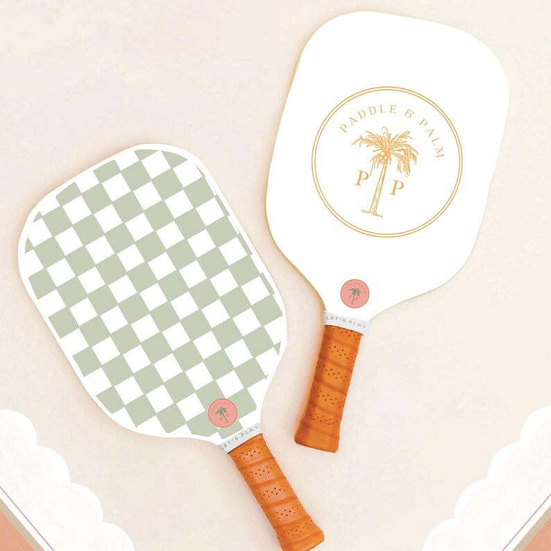 Both sides of a pickleball paddle, featuring a checkerboard pattern on one side, and the Paddle and Palm logo in yellow on the other side. The handle features chestnut brown grip tape.